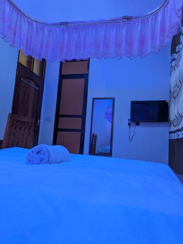 a bedroom with a bed with a blue light at New Harambee Hotel in Nakwa