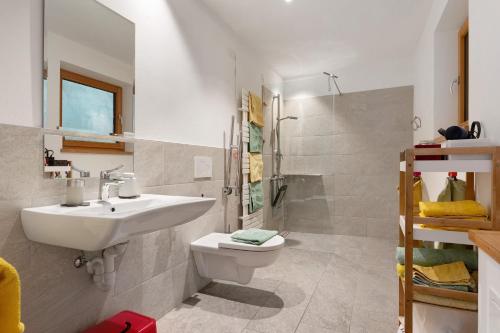 a bathroom with a sink and a toilet and a shower at Petrunderhof in Villnoss