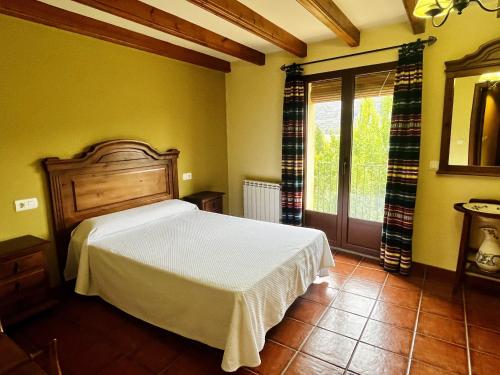 a bedroom with a white bed and a window at Cases Tonet in Forcall