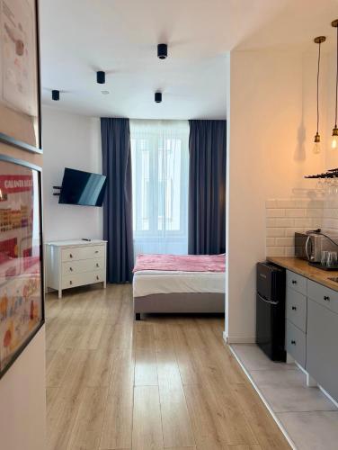 a small bedroom with a bed and a kitchen at BOOGIE Home Kamienica Łódzka in Łódź