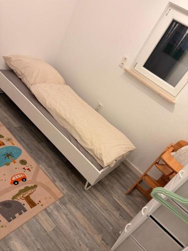 a small bedroom with a bed and a chair at Nur ein paar Schritte zum Dümmersee in Hüde
