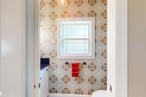 a bathroom with a window and a tile wall at Anchors Aweigh in Edgewater