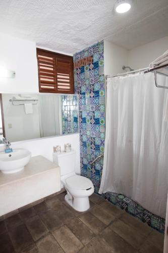 a bathroom with a toilet and a sink at Hotel Rosita in Puerto Vallarta
