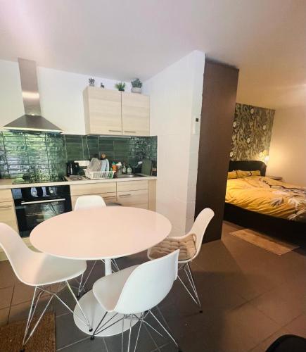 a kitchen with a table and chairs and a bed at Casa Sandra Elisa - Studio aan water in Maasmechelen