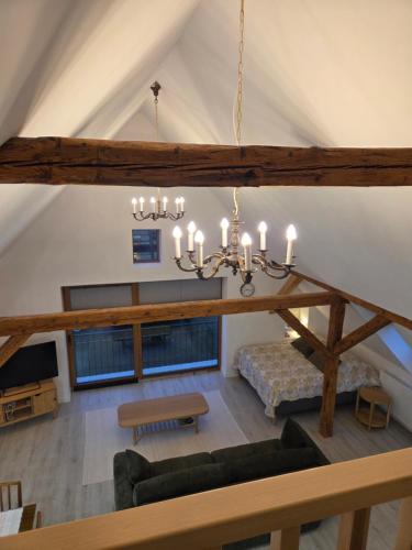 a large living room with a chandelier in a attic at Apartament Pod Orzechem in Ulinia