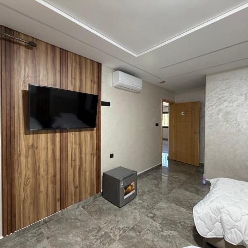 a bedroom with a flat screen tv on a wall at Chambre Triple Séjour Confortable à Berkane in Berkane