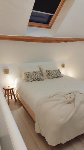 a bedroom with a white bed with a skylight at Maison Auguste - cosy - terrasse in Verberie
