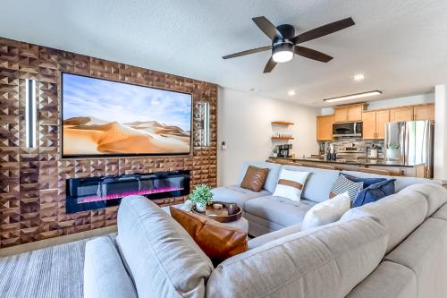 a living room with a couch and a large tv at Sunset Lakefront Retreat with Luxe Upgrades in Osage Beach