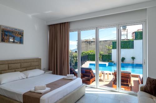 a bedroom with a bed and a view of a pool at Villa Myrtaj - Luxury Private Pool in Sarandë