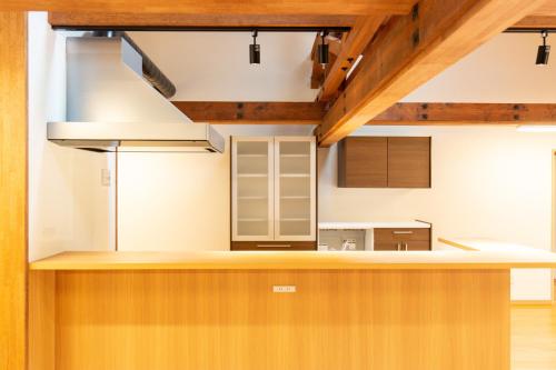 a kitchen with white walls and wooden ceilings at 森のオフィス Living in Fujimi