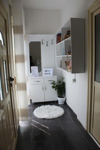 a kitchen with white cabinets and a rug on the floor at Nesti house in Orikum