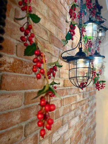 a brick wall with red berries and lights on it at BOOGIE Home Kamienica Łódzka in Łódź