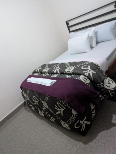a bed in a hotel room with a bedspread and pillows at Maneya Apartments in Kabwe