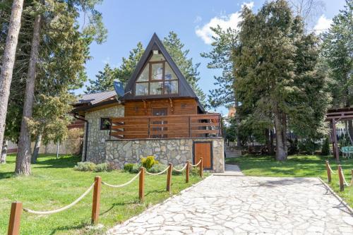 a cabin in the woods with a fence around it at Vila Paradiso in Zlatibor