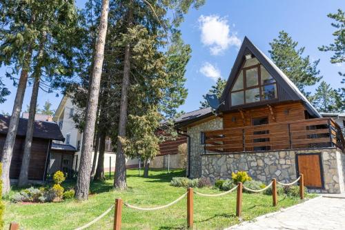 a log home with a fence in front of it at Vila Paradiso in Zlatibor