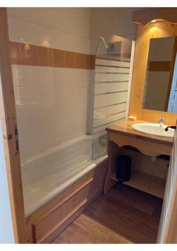a bathroom with a tub and a sink and a mirror at Appartement, 6 pers Casserousse 310 in Chamrousse
