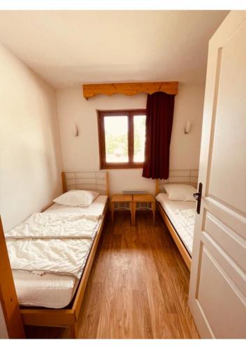 two beds in a small room with a window at Appartement, 6 pers Casserousse 310 in Chamrousse