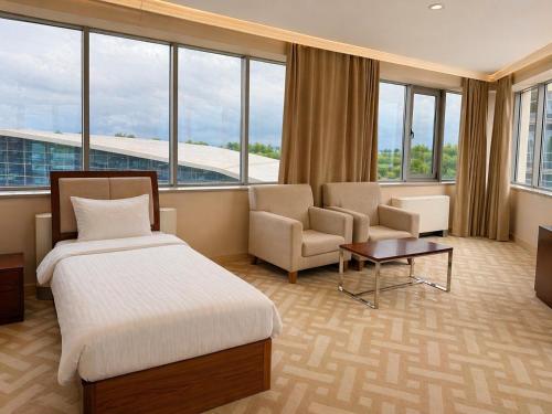a hotel room with a bed and a couch and chairs at Arena Hotel Kur in Mingachevir