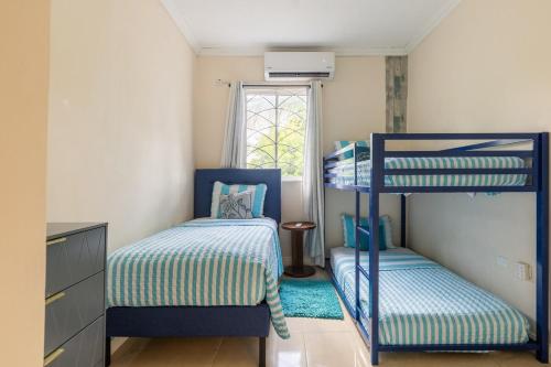 a bedroom with two bunk beds and a window at Palm Retreat in Ocho Rios