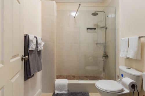 a bathroom with a toilet and a glass shower at Palm Retreat in Ocho Rios