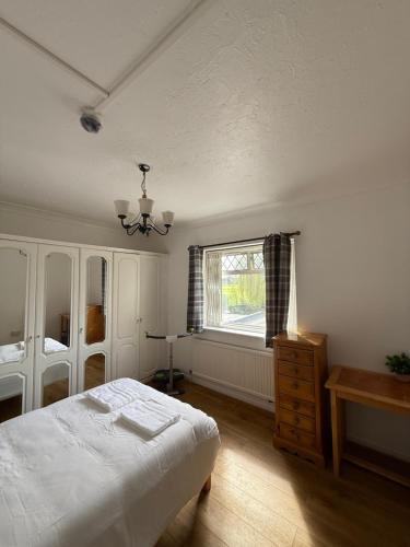 a bedroom with a white bed and a window at Park View in Goodmayes