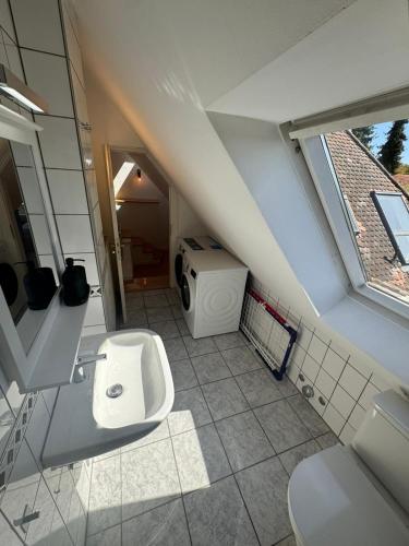 an attic bathroom with a toilet and a sink at Bavaria Home Kitchen Parks No 5 in Geisenfeld