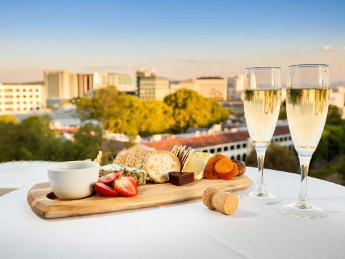 a tray of food and two glasses of champagne at Novotel Canberra in Canberra