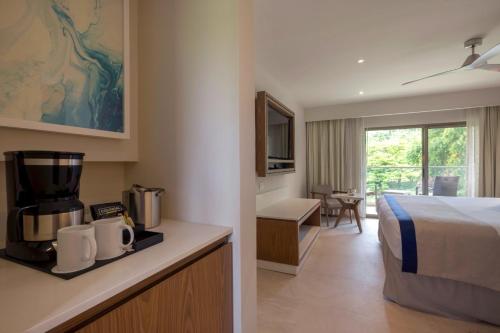 a hotel room with a bed and a kitchen at Royalton Grenada, An Autograph Collection All-Inclusive Resort in Bamboo
