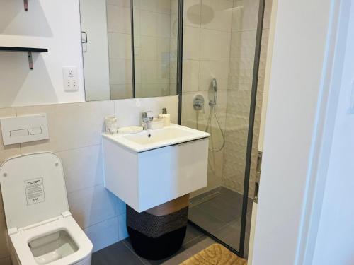 a white bathroom with a sink and a toilet at AccraAura-Airport Residential in Accra