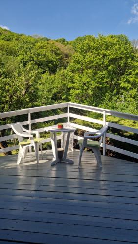 a table and a bench on a wooden deck at Albatross Duna Retreat in Dömös
