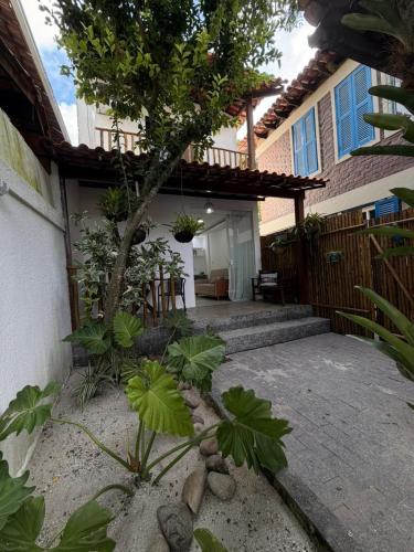 a courtyard of a house with a tree in front of it at Loft Itacoatiara in Niterói