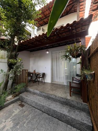a patio of a house with a table and chairs at Loft Itacoatiara in Niterói