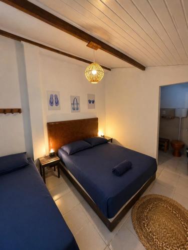 a bedroom with two beds and a chandelier at Nossa Casa Itacaré in Itacaré
