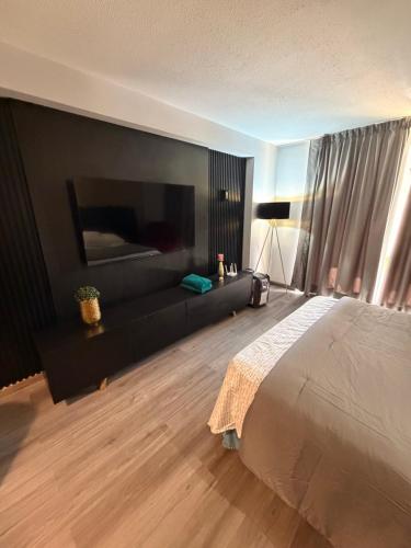 a bedroom with a large bed and a black wall at Apartamento vacacional en el Hotel Dynasty , Habitación tipo Estudio PRIVADO in Porlamar