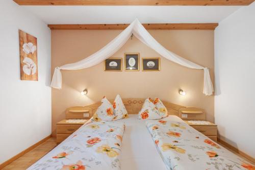 a bedroom with two beds and a canopy at Grafaierhof in Kastelruth