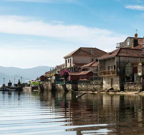 a group of houses next to the water at La Casa de las Ranas in Poio