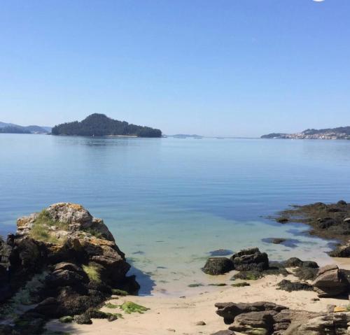 a view of a beach with rocks in the water at La Casa de las Ranas in Poio