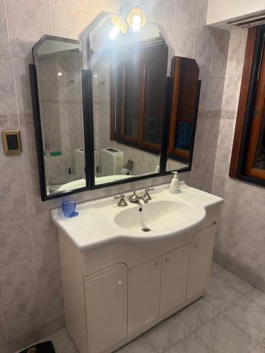 a bathroom with a white sink and a mirror at Hostel amplio y confortable in Munro