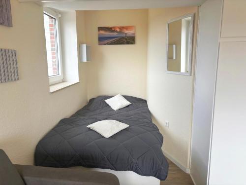 a small bed in a corner of a room at Tief 12 Seeigel 31 in Wangerland