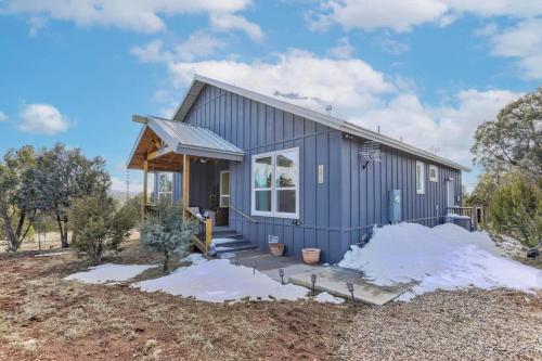 a small blue house with snow on the ground at Blue Betty Acre in Overgaard
