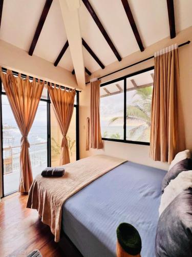 a bedroom with a large bed with a large window at Oceanfront House With Pool and BBQ in San Clemente