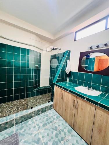 a bathroom with green tile and a sink and a tub at Oceanfront House With Pool and BBQ in San Clemente