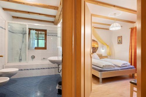 a bathroom with a bed and a shower and a sink at Grafaierhof in Kastelruth