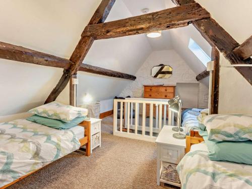 a attic bedroom with two beds and a crib at 3 Bed in Ventnor oc-93525 in Niton