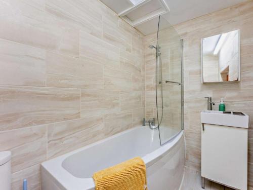 a bathroom with a tub and a sink and a mirror at 3 Bed in Ventnor oc-93525 in Niton
