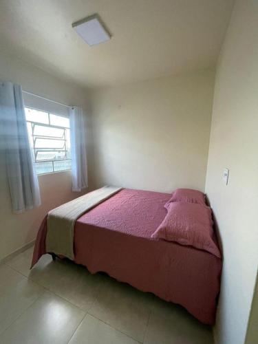a bedroom with a bed in a room with a window at Apartamento Salinas in Cacoal