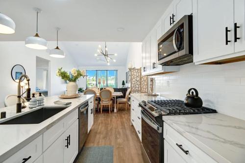 a kitchen with white cabinets and a stove top oven at Courtyard-Patio-Moutain and V3872-Holly House in Palm Desert