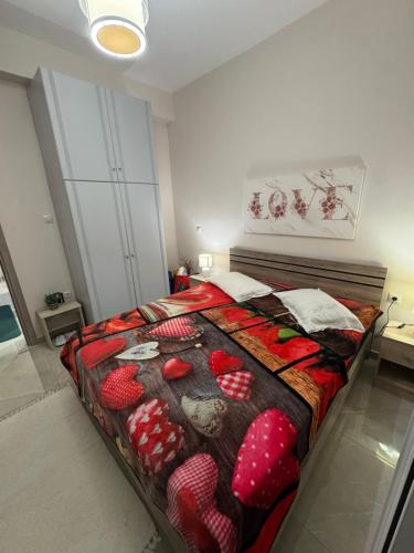 a bedroom with a bed with a red bedspread with strawberries on it at Gemini Downtown Apartment in Zakynthos