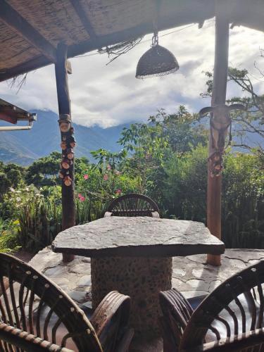 a stone table and chairs on a patio at El Cafetal in Coroico