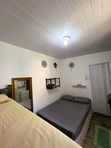 a bedroom with a bed and a mirror and a door at Camping e Pousada do Ade in Ilha do Mel